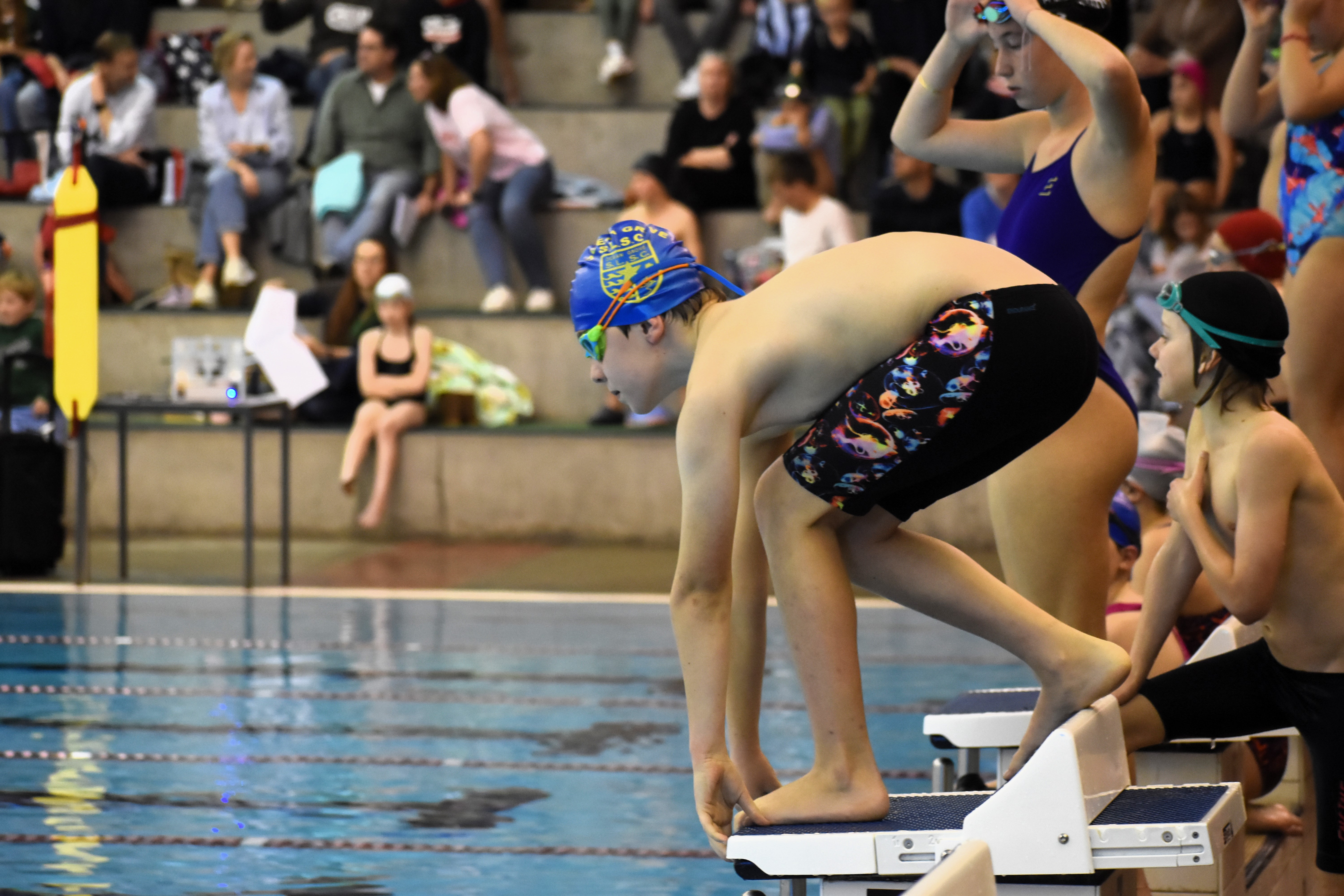 Action shot of a swimmer about to dive from the starting block at The Geelong College pool.
