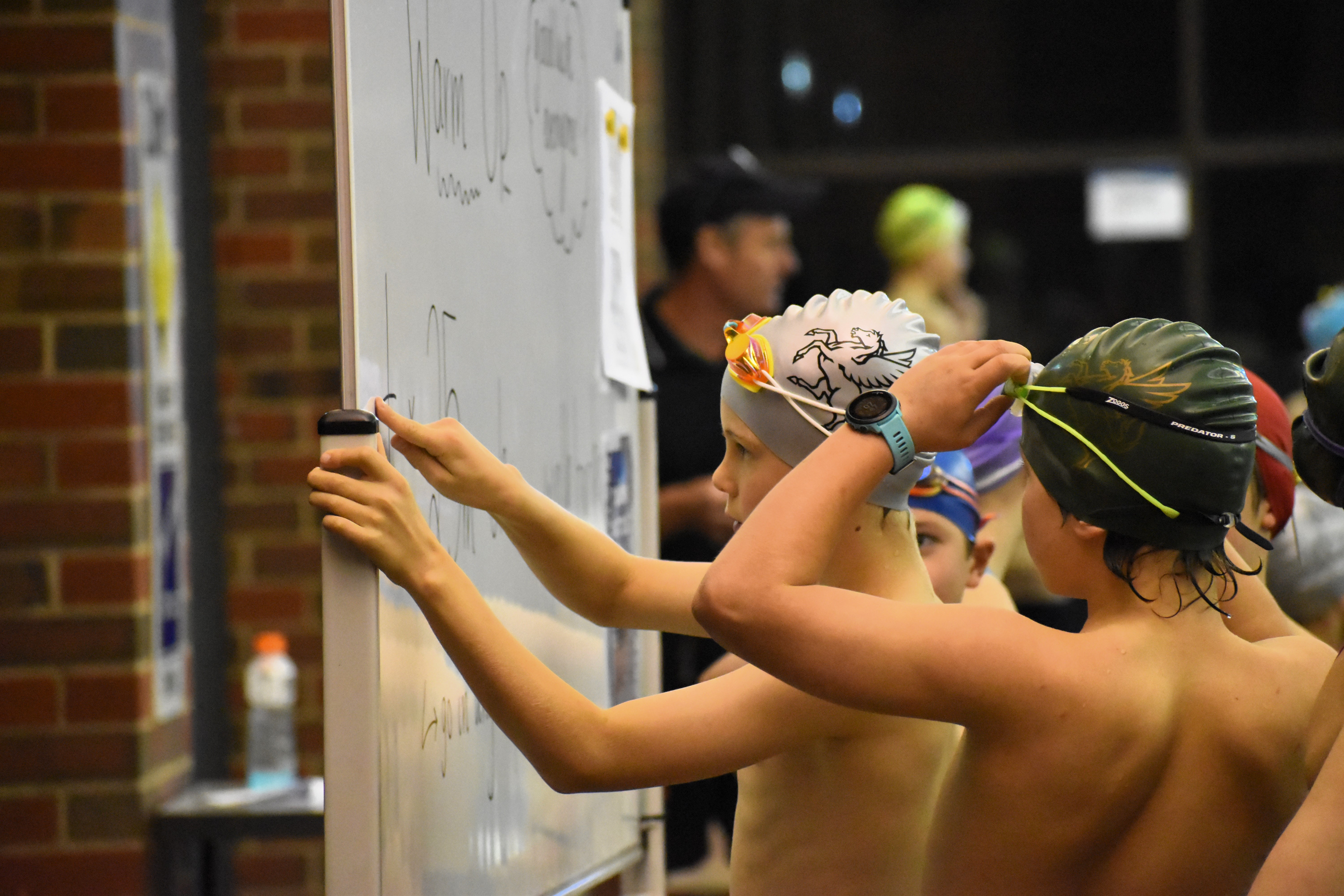 Young male student swimmer checking the race schedule during the swimming carnival at The Geelong College.